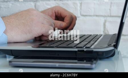 Businessman Using a Laptop and Working Online from Home, Man Accessing an Online Connection with Company Office Stock Photo