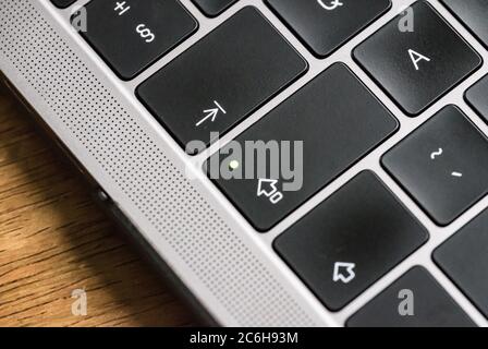 Close-up, shallow focus of a back-lit keyboard seen on a well-known, luxury computer manufacturer. Stock Photo