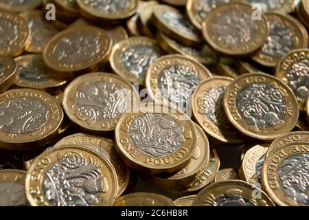 Photograph of random pile of new £1 coins (coins in circulation after October 2017) - selective focus on coins. Stock Photo
