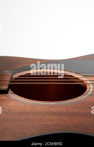 A close up of the top of a Fender acoustic guitar showing the sound hole and pickguard. Stock Photo