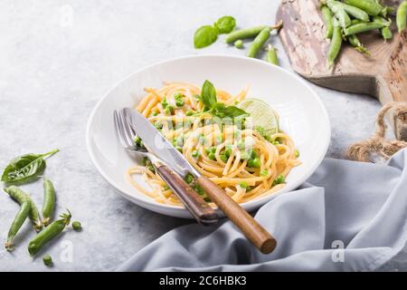 Italian pasta Cacio e Pepe - spaghetti with cheese and green pea Stock Photo