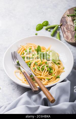 Italian pasta Cacio e Pepe - spaghetti with cheese and green pea Stock Photo