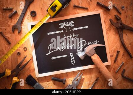 Happy Labor day background concept. Blackboard on wood with grunge and rusty  engineering handy tools arounds. Mockup chalkboard. Stock Photo