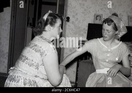 1950s, historical, ...a telling off!....'now listen to me young lady'....at home, a mother having a stern word with her teenage daughter, England, UK. In this era, discipline was important in households and parents had strict rules for possible wayward youngsters. Stock Photo