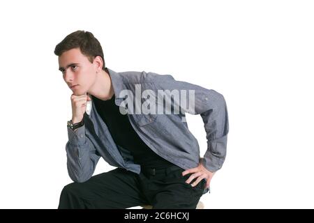 A young man in a Manatee shirt, black t-shirt and trousers, isolated on white. He puts his chin on his fist Stock Photo