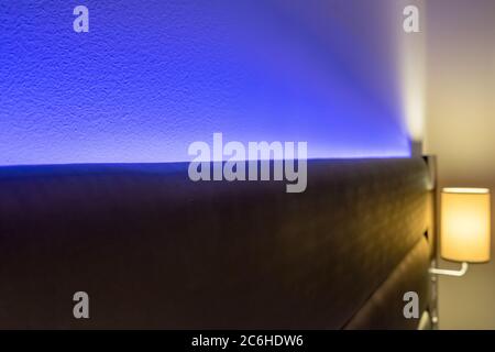 Shallow focus of modern LED ambient mood lighting seen in a modern apartment bedroom. The soft lighting acts to create a relaxing atmosphere. Stock Photo