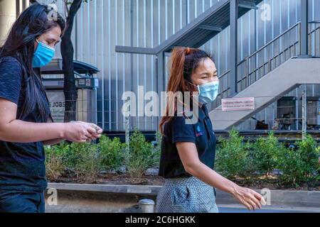 Girl wearing face mask using mobile phone during covid 19 pandemic, Bangkok, Thailand Stock Photo