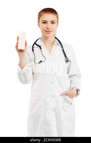 Portrait of a young female doctor in a white coat holding in hands a box with a new drug against a white background. Doctor holding an empty box with Stock Photo