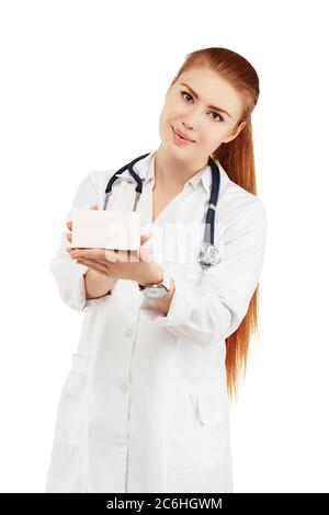 Portrait of a young female doctor in a white coat holding in hands a box with a new drug against a white background. Doctor holding an empty box with Stock Photo