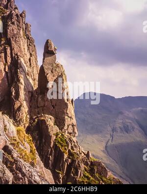 The image shows rock climbers in action scaling the Napes Needle rock formation on the side of Great Gable mountain at the head of the Wasdale valley in the English Lake District being a popular objective as a right of passage with rock climbers of every generation Stock Photo