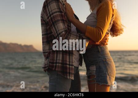 Mid section view of a Caucasian couple embracing on a promenade during sunset Stock Photo