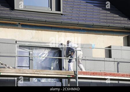 Construction workers insulates house facade Stock Photo