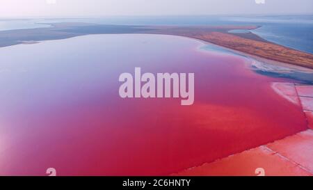 View from drone above the pink salty Genichesk lake, sand spit and blue sea at distance in Ukraine. Stock Photo