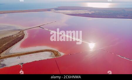 View from drone above the pink salty Genichesk lake, sand spit and blue sea at distance in Ukraine. Stock Photo