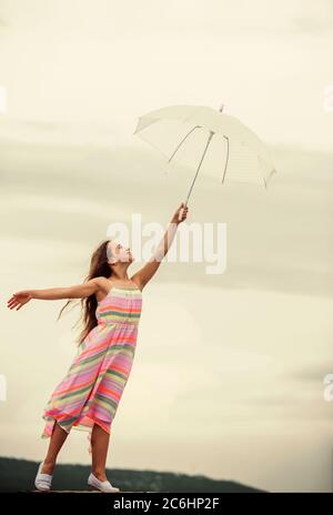 Touch sky. Girl with light umbrella. Fairy tale character. Happy childhood. Feeling light. Anti gravitation. Fly drop parachute. Dreaming about first flight. Kid pretending fly. I believe i can fly. Stock Photo