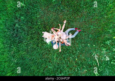 Family have a fun, picnic with pizza on a green grass, aerial view Stock Photo