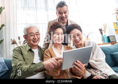 Happy middle-aged couples watch tablets Stock Photo