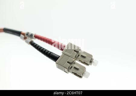 Macro image of super-fast Internet fibre optic patch leads used for high-speed, optical networking connections. Shown as a duplex pair of connectors. Stock Photo