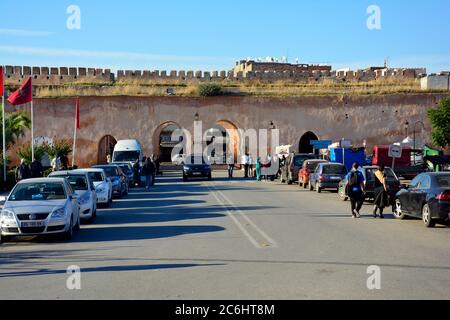 Meknes, Morocco - November 19th 2014: Unidentified people and cars in front of the medieval city wall with archways Stock Photo