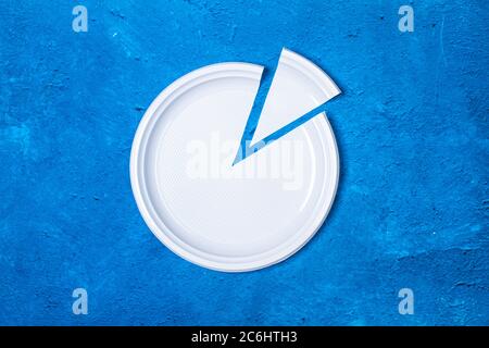 A cutted disposable white plate on a classic blue background Stock Photo