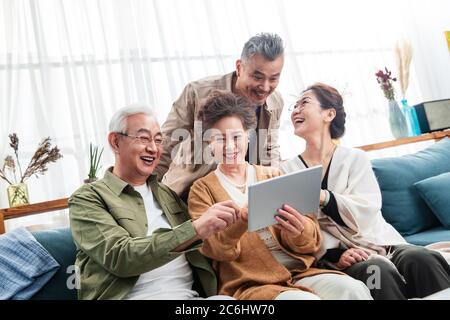 Happy middle-aged couples watch tablets Stock Photo
