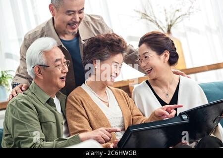 Happy middle-aged couples watch photo albums Stock Photo