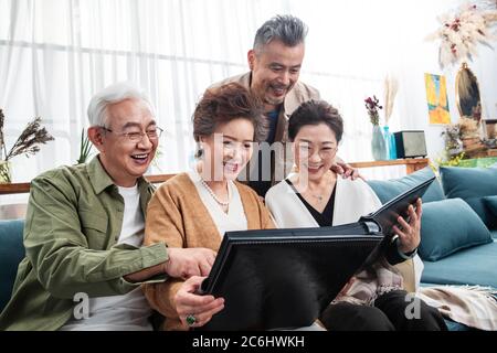 Happy middle-aged couples watch photo albums Stock Photo