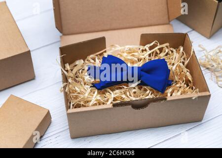 sewing craft business - packing blue fabric bow tie in cardboard box for shipping Stock Photo