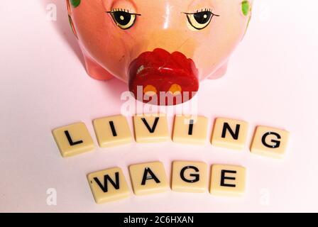 Financial concept image. Difficulty of living on low wages.  Gig economy. No savings.  words 'living wage' on tiles.  Idea shortage of cash.  povert i Stock Photo