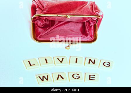 Financial concept image. Difficulty of living on low wages.  Gig economy. No savings.  Words 'living wage' on tiles.  Idea shortage of cash.  povert i Stock Photo
