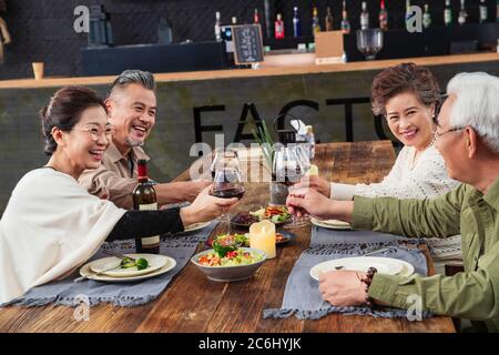 Toasting of middle-aged couples together in a restaurant Stock Photo