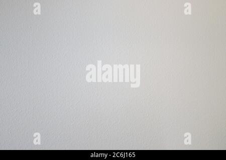 Off white wall background texture with decorative rough stippled surface in a full frame view Stock Photo