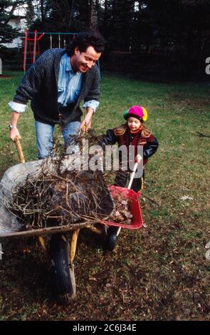 Kay Sabban, deutscher Schauspieler, sammelt mit seiner Tochter Laub im Garten in Hamburg, Deutschland 1990. Stock Photo