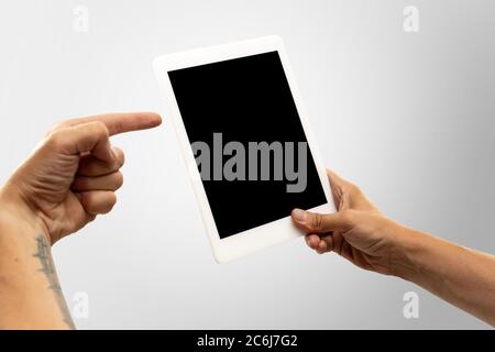 Pointing on screen. Close up male hands holding tablet with blank screen during online watching of popular sport matches, championships. Copyspace for ad. Devices, gadgets, technologies concept. Stock Photo