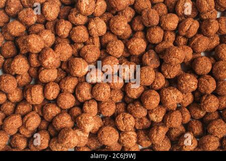Tasty and crispy cornflakes backdrop. Full frame of brown choco cereals Stock Photo