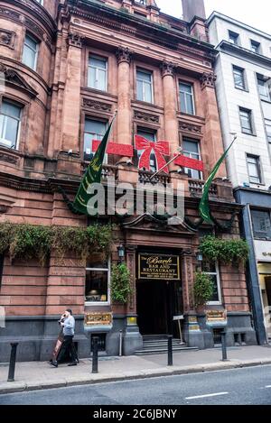 Dublin, Ireland - December 30, 2019: The Bank on College Green Bar and Restaurant with Christmas decoration and people around in Dame Street of Dublin Stock Photo