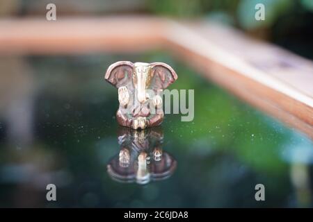 Ganesha deity in bronze on glas reflecting Stock Photo