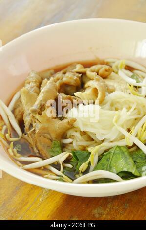 boiled thin rice noodles chicken leg and feet with bean sprout in herb brown soup on bowl Stock Photo