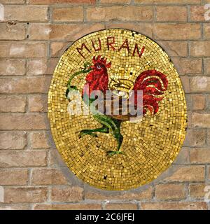 MURANO ISLAND, ITALY - SEPT 26, 2014: Colorful mosaic on the street of Murano. Rooster with a snake in its beak and a fox on the back - symbol of inde Stock Photo