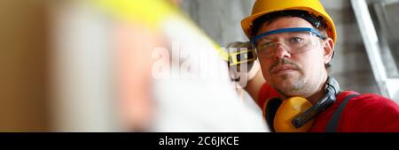Builder measuring wall level with roulette tape Stock Photo