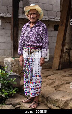 Guatemala, Solola Department, San Pedro la Laguna, 90 year old Mayan man in traditional dress stands in front of his home. Stock Photo