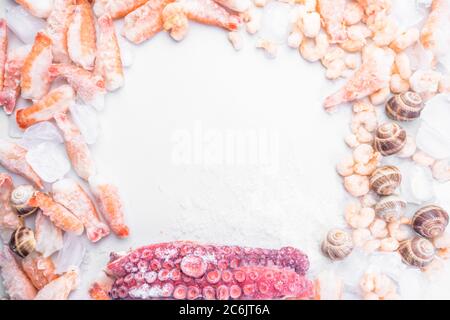 assortment of frozen seafood on ice cubes, shrimps, octopus, Babylonia areolata shellfish snails, langoustines, rich in iodine, antioxidants and vitam Stock Photo