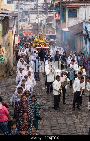 Guatemala, Solola Department, San Pedro la Laguna, A band plays in the Catholic procession of the Virgin of Carmen. Women in traditional Mayan dress with white mantillas over their heads.  Women carry the image of the Virgin in the procession. Stock Photo