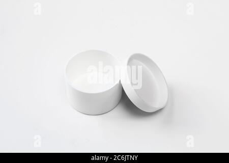 Plastic and empty white box on white background. Small,opened packaging mockup for medicine. Round design Stock Photo