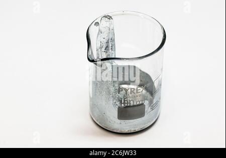 The element Gallium in a glass beaker in the lab. Stock Photo