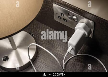 A table lamp plugged into a wall socket in the UK Stock Photo - Alamy