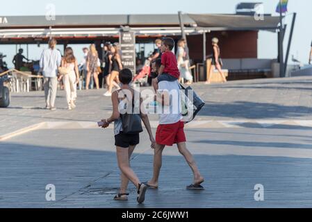 Cadaques, Spain : 07 JULY 2020 : People in the beach and houses of the village of Cadaques, Spain in summer on 07 july 2020. Stock Photo