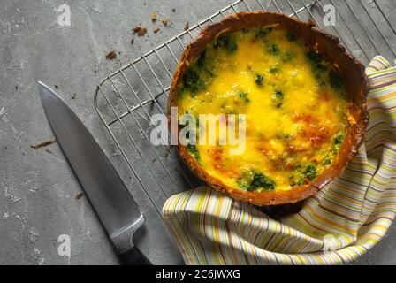 Tasty Homemade French pie or Quiche lorraine salmon pie on baking rack. Big knife. Top view Stock Photo