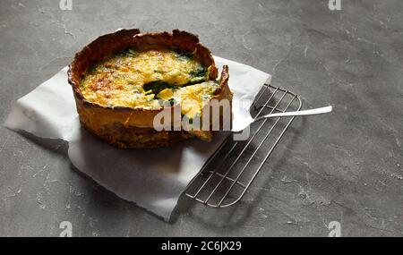 Sliced Homemade French pie or Quiche lorraine salmon pie on baking rack. Stock Photo
