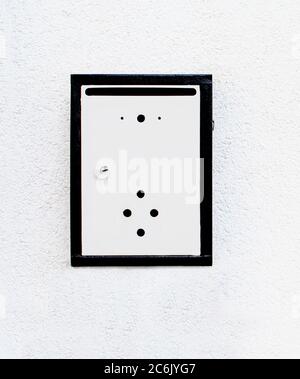 Metal mailbox on white wall. Empty Letterbox/post box isolated Stock Photo